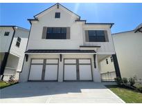 Two-story home with white brick exterior, three-car garage, and landscaping at 1883 Westfall Landing, Auburn, GA 30011