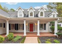 Elegant home with a red door and a spacious covered porch at 220 Spring Branch Dr, Canton, GA 30115