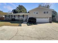 Brick ranch house with attached garage and landscaped yard at 1672 Scufflegrit Rd, Marietta, GA 30062