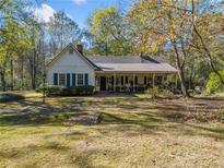 Charming one-story home with white siding, green shutters, and a front porch at 1765 Holly Springs Ne Rd, Marietta, GA 30062