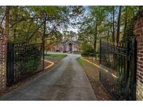 Brick columns and gates open to a long driveway leading to a beautiful home at 5211 Hadaway Nw Rd, Kennesaw, GA 30152