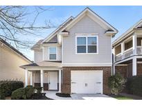 Charming two-story home with a brick and siding exterior, attached garage, and inviting front porch at 611 Shadow Valley Ct, Lithonia, GA 30058