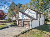 Two-car garage with brown doors and white exterior at 3373 Northumberland Pl, Roswell, GA 30075