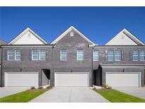 Three-unit townhome building with gray brick exterior and attached garages at 224 Epping St # 7, Stockbridge, GA 30281