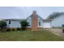 Gray house with brick chimney and attached garage at 2073 Marbut Ln, Lithonia, GA 30058