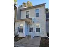 Two-story beige townhome with white trim and landscaping at 6500 Wellington Chase Ct, Lithonia, GA 30058
