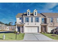 Two-story townhome with attached garage and front yard at 2615 Quarterdeck Dr, Cumming, GA 30041