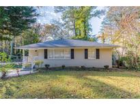 Ranch style home with a well-manicured lawn and mature trees at 2301 Delowe Dr, Atlanta, GA 30344