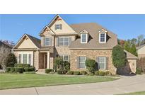 Two-story brick home with stone accents, landscaped lawn, and a paved driveway at 2420 Bronze Ct, Cumming, GA 30041