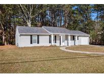 Ranch style home with gray siding, attached garage, and landscaped lawn at 3015 Flat Shoals Rd, Atlanta, GA 30349