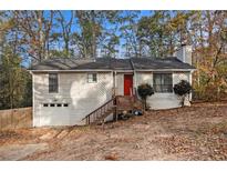 Ranch house with red door, wooden steps, and attached garage at 3060 Wilkes Plantation Way, Douglasville, GA 30135