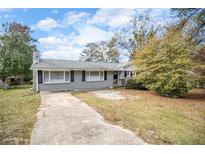 Ranch style home with gray exterior, landscaping, and a long driveway at 4257 Midway Rd, Douglasville, GA 30134