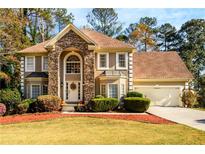 Two-story house with stone accents, a three-car garage, and manicured landscaping at 1379 Christiana Dr, Lawrenceville, GA 30043