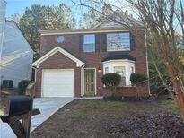 Two-story brick home with attached garage and landscaping at 7069 Ravenwood Ln, Lithonia, GA 30038