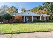 Brick ranch home with a large front yard and mature trees at 1028 Ridge Ave, Stone Mountain, GA 30083