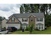 Two-story home with stone accents, attached garage, and landscaped front yard at 6415 Grey Fox Way, Riverdale, GA 30296