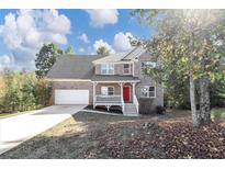 Two story brick home with attached garage and red door at 909 Galloway Ct, Mcdonough, GA 30253
