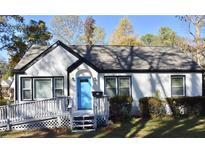 Charming white brick ranch with a bright blue door, gray ramp, and well-manicured lawn at 2502 Tupelo Se St, Atlanta, GA 30317