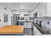 Modern kitchen with stainless steel appliances and white shaker cabinets at 89 Chaumont Nw Sq, Atlanta, GA 30327