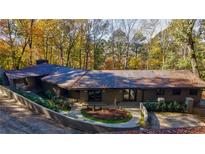 Stunning aerial view of a contemporary home nestled in a wooded setting at 5088 Riverview Rd, Atlanta, GA 30327