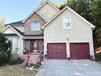 Two-story house with stone accents and a red door at 3668 Deer Springs Pkwy, Ellenwood, GA 30294