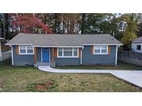 Newly renovated ranch home featuring a gray exterior, blue door, and landscaped yard at 26 Reeves St, Norcross, GA 30071