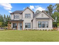 Two-story farmhouse with white brick, gray roof, and a welcoming front porch at 2810 Herrington Dr, Cumming, GA 30041