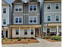 Three-story townhome with gray siding, brick accents, and a covered porch at 2108 Irvin Ct, Kennesaw, GA 30144