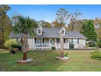 House exterior featuring a two-story home with a landscaped yard and palm trees at 201 Nina Cir, Locust Grove, GA 30248