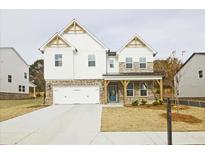 Two-story home with brick and white siding, a covered porch, and a two-car garage at 3952 Adler Cir, Buford, GA 30519