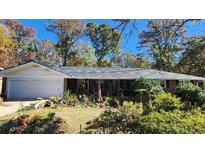 Brick ranch home with attached garage, mature landscaping, and a spacious front yard at 2479 Landeau Cir, Tucker, GA 30084