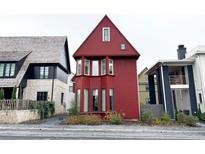 Red three-story house with bay windows and landscaping at 290 2Nd St, Fayetteville, GA 30214