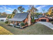 Charming log cabin home with a large backyard and detached garage at 923 Pine Cir, Woodstock, GA 30189