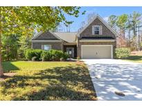 Brick home with two-car garage and landscaped lawn at 515 Ankara Ct, Fairburn, GA 30213