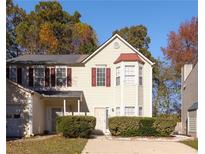 Two-story house with beige siding, red accents, and landscaping at 2981 Falling Water Pt, Atlanta, GA 30349