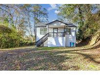 Charming white house with a front porch and steps, nestled among trees at 1490 Broad Ne St, Conyers, GA 30012