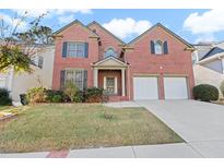Brick two-story house with a two-car garage and manicured lawn at 727 Pear Grove Pl, Marietta, GA 30066