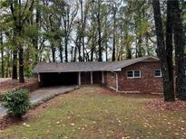 Brick ranch home nestled on a wooded lot with a large front yard at 2820 Arlington Rd, Atlanta, GA 30344