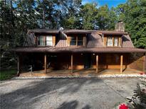 Inviting log cabin home with a spacious front porch and a metal roof at 3934 S Rockbridge Rd, Stone Mountain, GA 30083