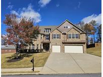 Two story brick home with three car garage and landscaped yard at 4560 Lake Hill Trl, Ellenwood, GA 30294