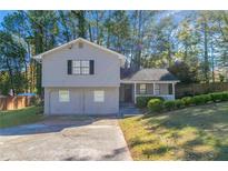 Gray two-story house with a two-car garage and a landscaped yard at 5382 Kemper Pl, Stone Mountain, GA 30088
