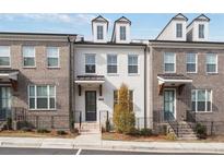 White and brown brick townhome with a charming front porch at 1309 Bennett Creek Ovlk, Suwanee, GA 30024