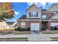 Brick townhouse with a two-car garage and well-maintained landscaping at 2555 Flat Shoals Rd # 1801, Atlanta, GA 30349