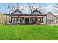 Gray craftsman style home with a large front porch and nicely landscaped lawn at 4900 Lilburn Stone Mountain Sw Rd, Lilburn, GA 30047