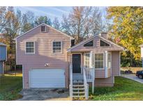 Charming light pink house with attached garage and a small front porch at 223 Clydesdale Se Ln, Mableton, GA 30126