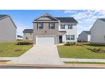 Two-story house with gray brick and white siding, two-car garage, and landscaped lawn at 158 Aster Ave, Locust Grove, GA 30248