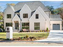 Two-story white brick house with black windows, gray roof, and landscaped lawn at 4895 Lansbury Dr, Atlanta, GA 30342