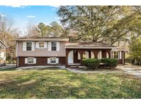 Brick ranch home with a covered porch and well-maintained landscaping at 2670 Foxlair Trl, Atlanta, GA 30349