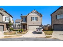 Two-story house with beige siding, attached garage, and a well-manicured lawn at 2291 Elise Way, Hampton, GA 30228