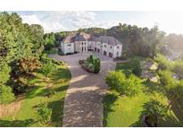 Luxury home with extensive landscaping and a large circular driveway at 1513 Jones Rd, Roswell, GA 30075